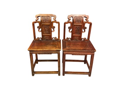 Lot 1519 - Pair of antique Chinese hardwood chairs, each with pierced and carved back, centred by carved low relief figural reserve, solid seat over carved frieze on square supports and stretchers