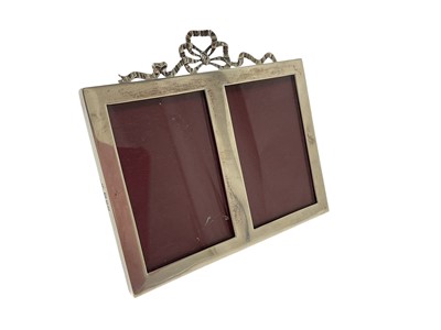 Lot 337 - Double silver photograph frame, with ribbon decoration and wooden easel back (London 1911) William Comyns, 14.5cm high