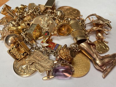 Lot 96 - 9ct gold charm bracelet with a good collection of gold and yellow metal charms including a George V half sovereign, 1913.