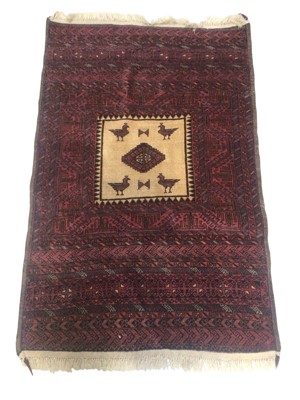 Lot 5285 - Persian Baluch rug on a red background, 150cm x 93cm