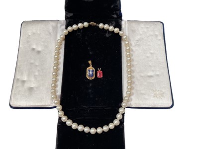 Lot 48 - Egyptian yellow metal and enamel scarab beetle pendant, 14k gold mounted pink stone pendant and a cultured pearl single string necklace with 14k clasp (3)
