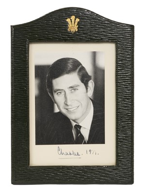 Lot 121 - H.R.H. Prince Charles, Prince of Wales, signed 1977 portrait photograph of the smiling Prince signed I. Ink in mount 'Charles 1977' in original green Morocco leather frame