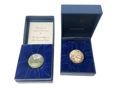 Lot 66 - H.R.H. Prince Charles, Prince of Wales, two Royal presentation Halcyon Days enamel boxes decorated with landscapes and Prince of Wales feather crests dated 1999 and 2000, in original fitted boxes (2)