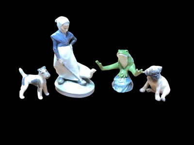 Lot 2216 - Four Royal Copenhagen ornaments to include a leaping frog, no, 556 with booklet, two dogs and figure of a girl with a goose