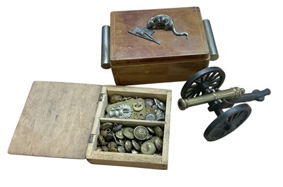 Lot 726 - Second World War period wooden box mounted with a rat eating flags including the Japanese and Nazi German flags, together with a collection of military badges, buttons and a model cannon.