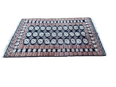 Lot 5276 - Eastern rug with central medallions on black and brown ground, 180cm x 121cm, together with another cream rug, 209cm x 155cm (2)