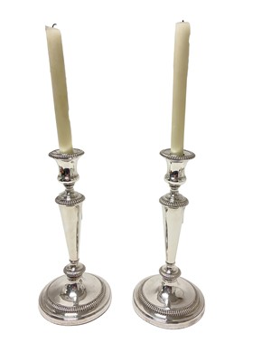 Lot 380 - Pair of silver plated candlesticks with removable sconces and gadrooned borders, 30cm high