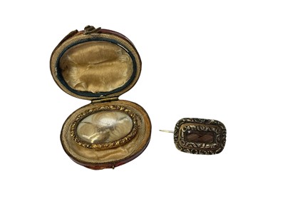 Lot 166 - Two 19th century glazed yellow metal mourning brooches with hairwork decoration, dated 1830 and 1894, in an antique leather box