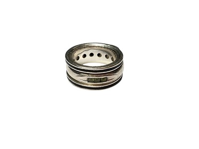 Lot 245 - White metal gem set ring with a rotating centre band, inlaid with elephant hair and set with various gemstones, within a black enamel border