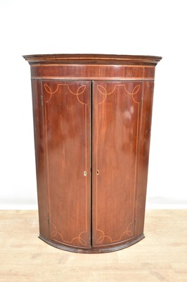 Lot 1378 - George III mahogany bowfront corner cupboard with inlaid stringing