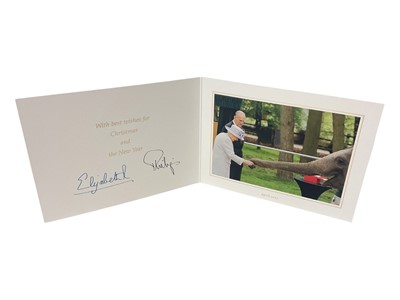 Lot 48 - H.M. Queen Elizabeth II and H.R.H. The Duke of Edinburgh signed 2017 Christmas card with twin gilt cyphers to cover, colour photograph of the smiling Royal couple feeding an elephant to the inter...