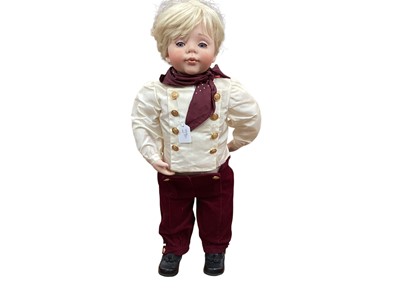 Lot 1880 - Large modern girl and boy ceramic collectable dolls with wooden stands.