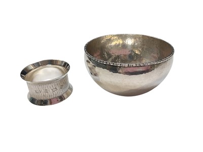Lot 188 - Contemporary silver napkin ring with bark effect decoration (Birmingham 1974) together with a white metal bowl with hammered finish, 9.5cm diameter (2)