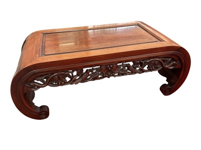 Lot 1436 - Late 19th / early 20th century Chinese hardwood low opium table , with recessed panel top and carved bow end panels, pierced carved frieze on scrolled feet