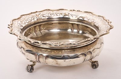 Lot 459 - Edwardian silver rose bowl of cauldron form with pierced pie crust border, raised on three scroll feet, (London 1907), maker Sibray, Hall & Co Ltd, all at 30.44ozs, 27.5cm in diameter.