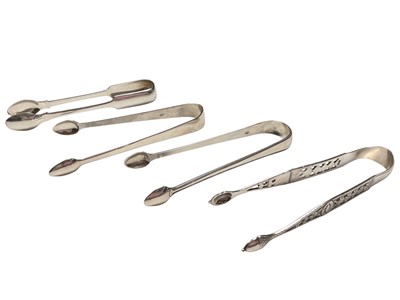Lot 194 - Two pairs of Georgian silver sugar tongs, another silver pair with pierced decoration and acorn shaped bowls, and a plated pair of tongs (4)