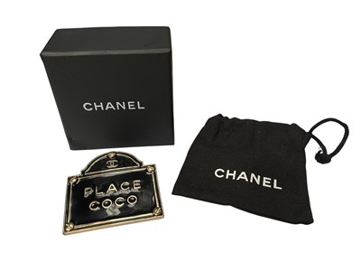 Lot 284 - Chanel 'Place Coco' gold plated and black enamel brooch, circa 2015