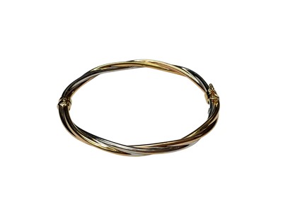 Lot 252 - 9ct yellow and white gold twist design hinged bangle