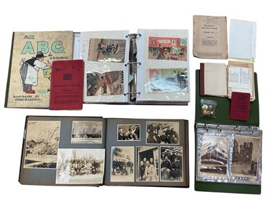 Lot 1196 - A 1940s photograph album of Japanese military groups, activities, street scenes, parades, some family portraits. Plus an album of postcards including real photographic street scenes, cats, mili...