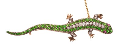 Lot 552 - Victorian demantoid green garnet and diamond lizard brooch with pavé set body and ruby cabochon eyes, in silver and gold setting, 59mm.