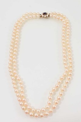Lot 630 - Cultured pearl two-strand necklace with two strings of 6.3mm cultured pearls on a 9ct gold amethyst and pearl cluster clasp, approximately 46cm.