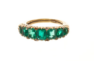 Lot 557 - Victorian emerald seven stone half hoop ring with seven graduated emeralds with rose cut diamond accents to the claws, in carved gold setting on tapered gold shank, ring size I.