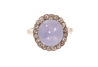 Lot 559 - Edwardian star sapphire and diamond cluster ring with a cabochon star sapphire measuring approximately 10.2mm x 9.6mm x 7.25mm, surrounded by a border of old cut diamonds in millegrain setting o...