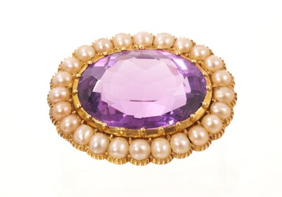 Lot 574 - Victorian amethyst and pearl brooch with an oval mixed-cut amethyst surrounded by a border of half pearls in gold setting, 28mm