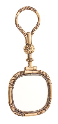 Lot 591 - Regency yellow metal magnifying glass with cast and chased foliate decoration, 78mm.