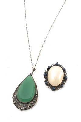Lot 597 - Arts & Crafts green stone pendant in silver mount with trailing leaves, on a silver chain with toggle clasp, together with a mother of pearl pendant (2)