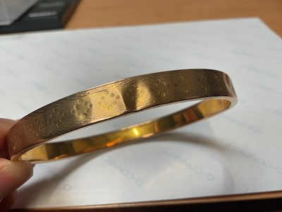 Lot 31 - 9ct gold bangle with engine turned decoration