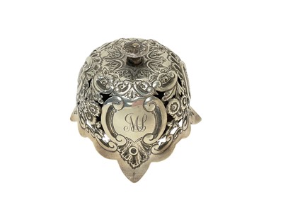 Lot 463 - Victorian silver table bell with pierced and embossed foliate and scroll decoration and engraved initials, (Birmingham 1897), maker, Samuel Walton Smith, 9.5cm in diameter.