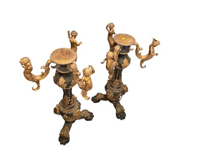Lot 5377 - Pair of Italianate painted and gilt heavy cast metal pedestals, with figural supports and paw feet, 75cm high