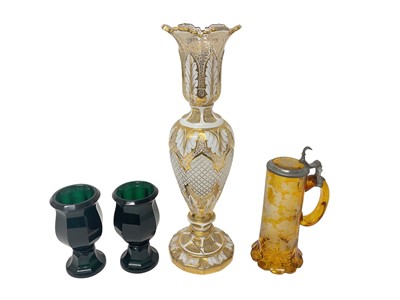 Lot 330 - Large Bohemian flash cut glass vase, 34.5cm high, together with a Bohemian amber tankard engraved with grapevines, and a pair of green cut glass goblets, possibly Moser (4)