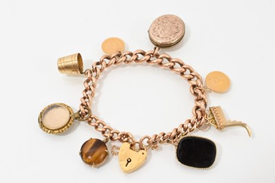 Lot 660 - Gold charm bracelet with a collection of gold and antique yellow metal / gilt metal charms