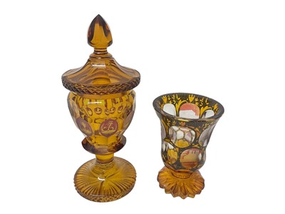 Lot 331 - Two Bohemian cut glass amber vases, one engraved with cameos of German towns, the other with hunting emblems and other scenes, 15.5cm and 21.5cm high (2)