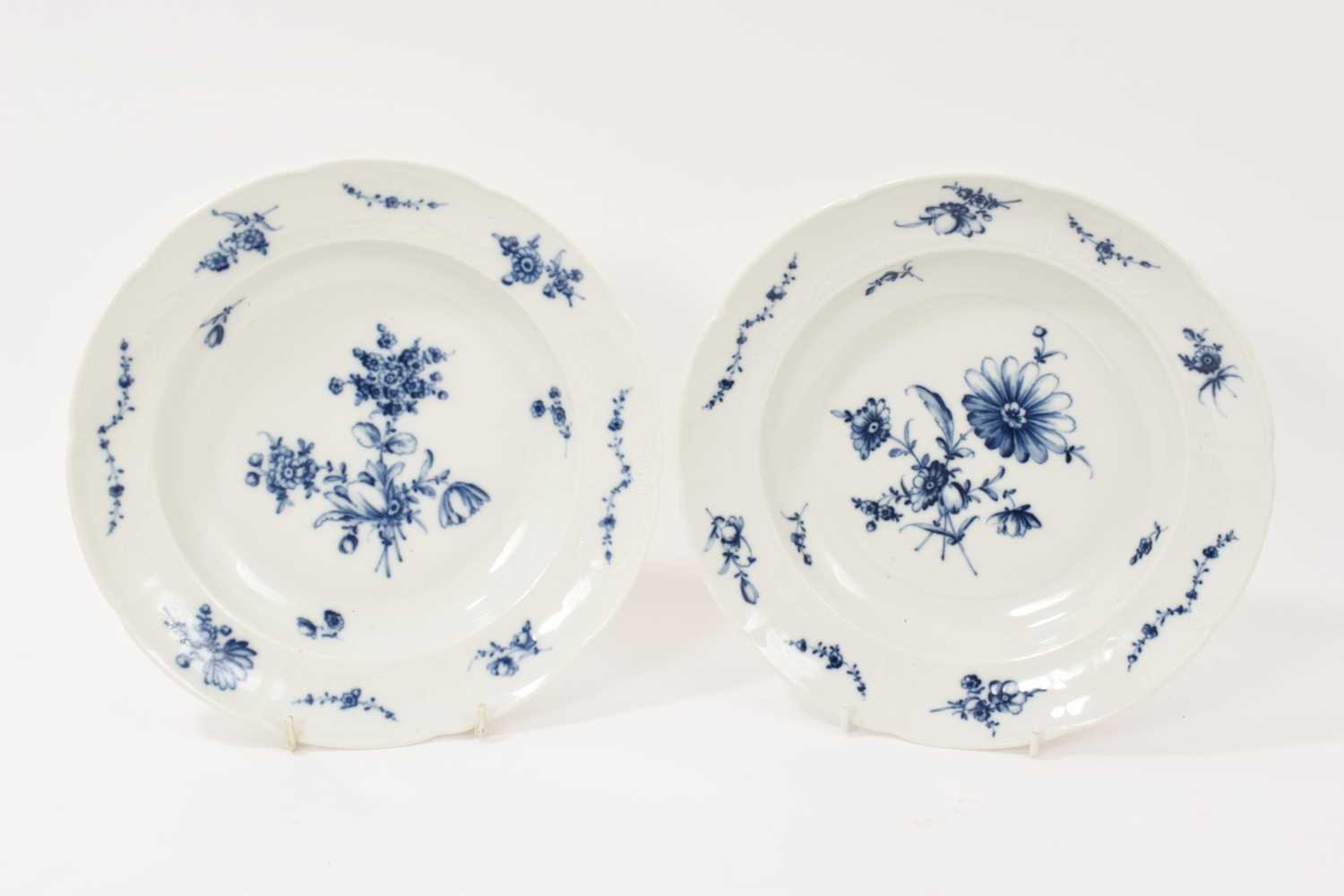 Lot 5037 - Two 18th century Furstenberg porcelain shallow plates, painted with floral sprays and swags, the edge moulded with scrollwork cartouches, underglaze blue 'F' mark to bases, 23.75c diameter