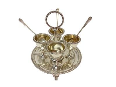 Lot 454 - Victorian silver egg cruet, comprising four silver egg cups, each with gadrooned borders, together with a matching stand, (Sheffield 1897), maker Henry Atkin, and four (non matching) silver teas...