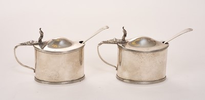Lot 456 - Pair of Edwardian silver mustard pots of oval form with reeded borders and blue glass liners to interiors, (Chester 1908), maker Stokes & Ireland Ltd, together with two non matching silver m...