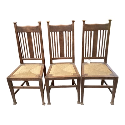 Lot 5302 - Three Arts & Crafts oak dining chairs with rush seats, ex-Sotheby's label.