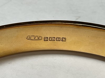 Lot 59 - 18ct gold hinged bangle with engraved floral scroll decoration to one side (Birmingham 1962)