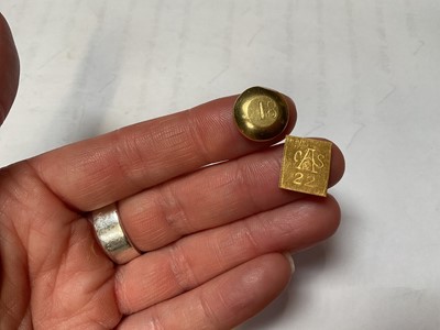 Lot 63 - Two yellow metal nuggets, the round disc stamped 18 and rectangular plaque stamped 22