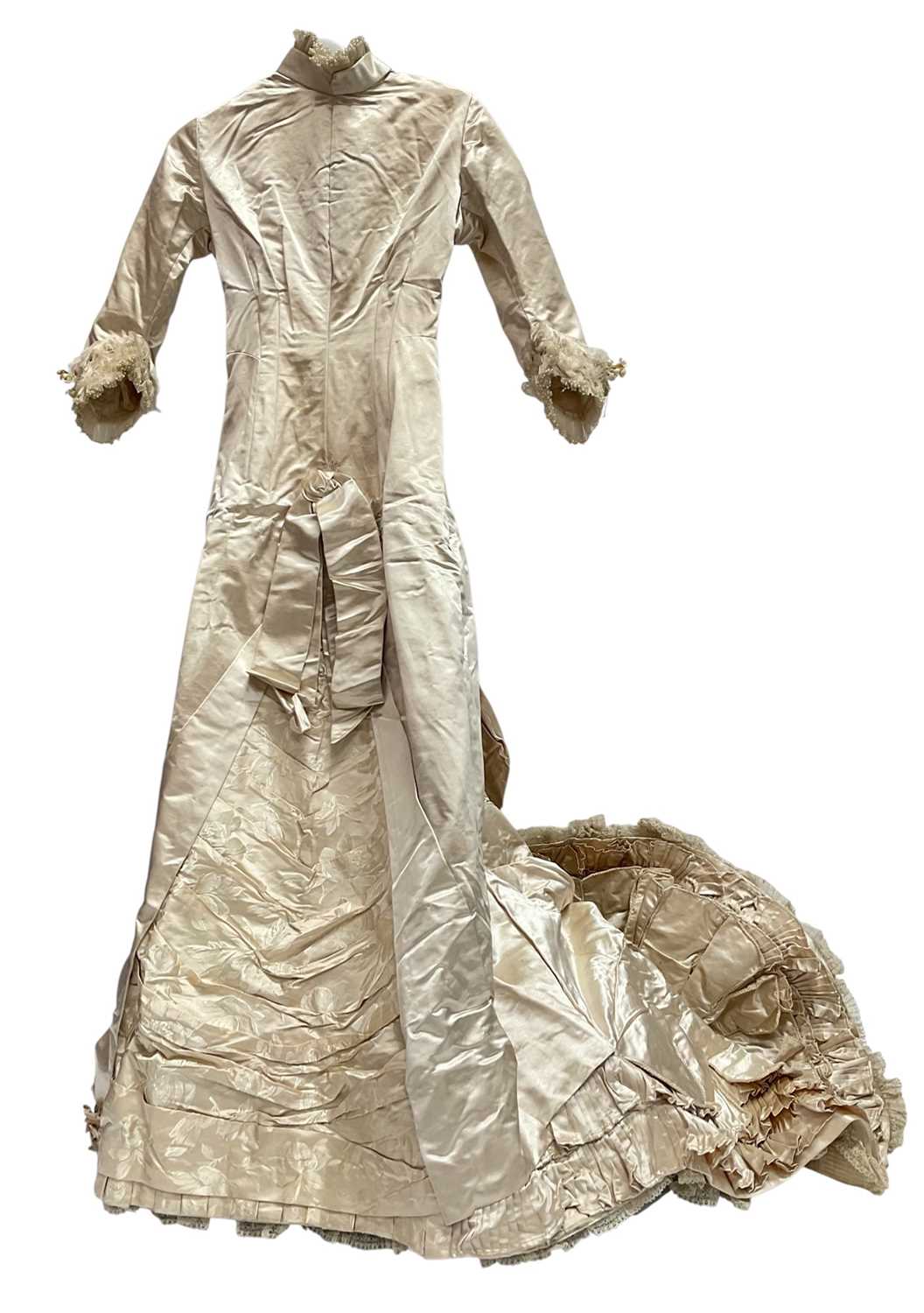 Lot 2500 - Exquisite 1882 wedding dress, cream satin silk with multi pleated trims, lace and tiny faux pearls to cuffs, hem and train. Front has boned bodice , ruched cream silk brocade panel with bow det...
