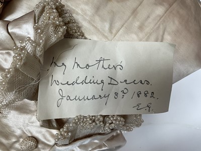 Lot 2500 - Exquisite 1882 wedding dress, cream satin silk with multi pleated trims, lace and tiny faux pearls to cuffs, hem and train. Front has boned bodice , ruched cream silk brocade panel with bow det...
