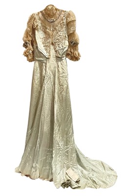 Lot 2503 - 1911 evening gown by Mary Elizabeth Humble, Conduit Street, London Eau De Nil silk, voluminous elbow length sleeves in layered lace with ribbon and button trim, lace bodice overlaid embroidere...