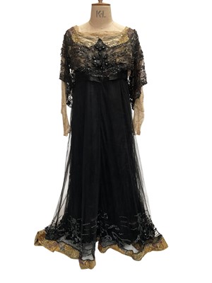 Lot 2506 - 1911-1912 Black silk and silk-crepe dress with black net overlay. Elaborate black beading and sequinnes on boned bodice, sleeve overlay and bottom of dress. Lace sleeves, lace insert on bodice...
