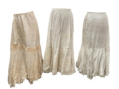 Lot 2510 - Edwardian flounced, embroidered and lace trimmed petticoats including three cotton and one silk with fine pleating.