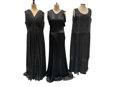 Lot 2519 - Group of 1920s / 30s black dresses including beaded cocktail dress, layered lace evening dress, gown with chiffon and lace panels and black slip, asymmetric cut satin gown and two other long d...