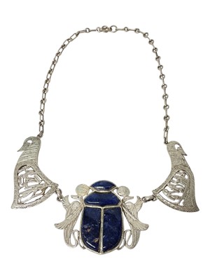 Lot 14 - Egyptian white metal and blue stone scarab beetle pendant necklace with pierced and carved white metal panels depicting birds and Egyptian figures