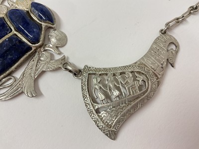 Lot 14 - Egyptian white metal and blue stone scarab beetle pendant necklace with pierced and carved white metal panels depicting birds and Egyptian figures